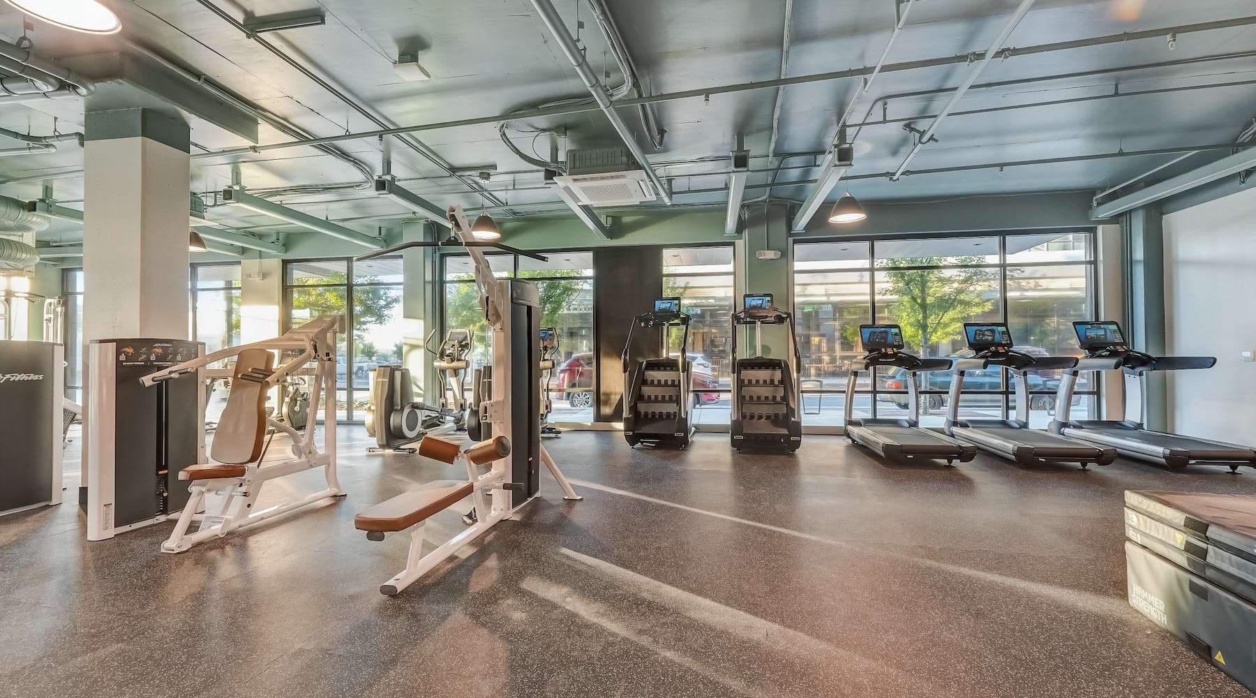 fitness center with rows of treadmills and modern style flooring