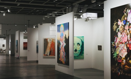 A vertical gallery wall with light-colored frames and botanical prints - wall decor for studio apartments